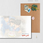Load image into Gallery viewer, Arab family illustrated birthday card showing a father and two children leaning over a white cake with whipped cream and red cherries. Father wears blue knock-off Nike sweats, and the boy wears a CEIKO digital watch. Handwritten labels highlight details like ‘Dad’s knock off Nike Sweats,’ ‘Cherries that no one eats,’ and ‘Gateaux Nabil Fancy Cake.’ Card sits on a brown envelope with wax seal and dried flowers. Arab family gift, birthday card, nostalgic design.
