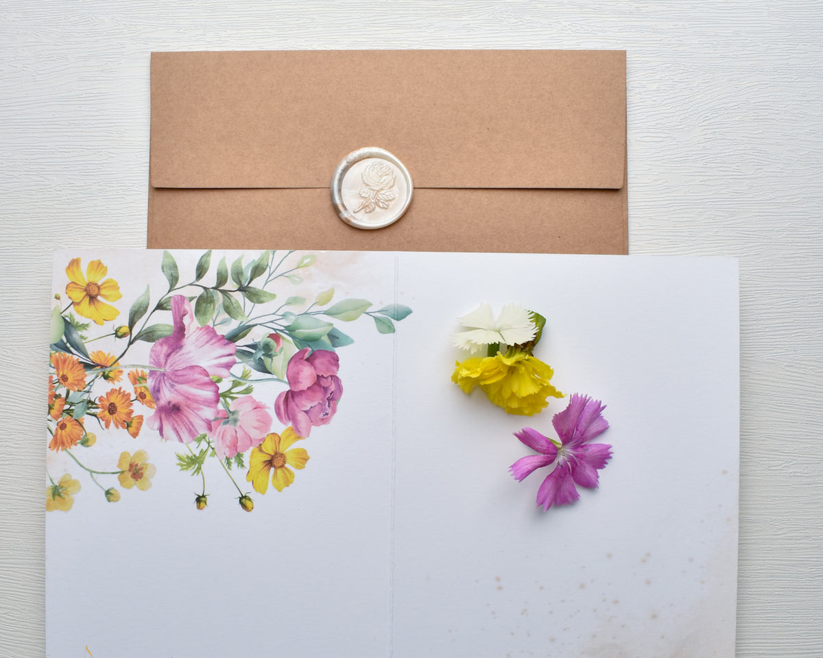 Floral card with a wax seal and decorative envelope on a white background