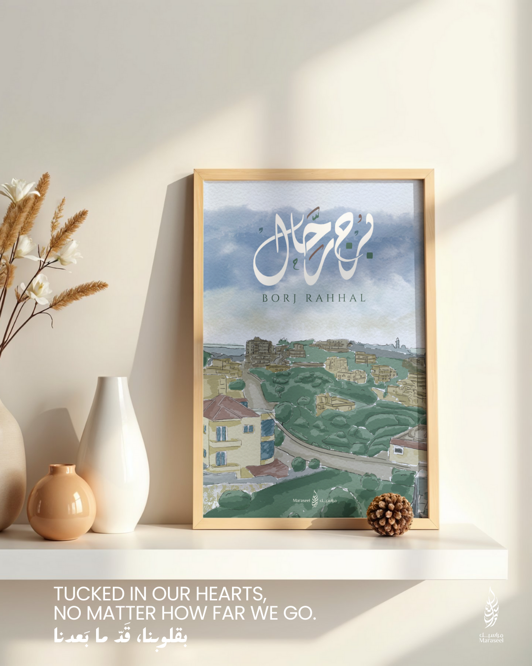 Borj Rahhal art print displayed on a shelf with soft morning light, minimal vases, and the bilingual tagline “Tucked in our hearts, no matter how far we go” in English and Arabic.
