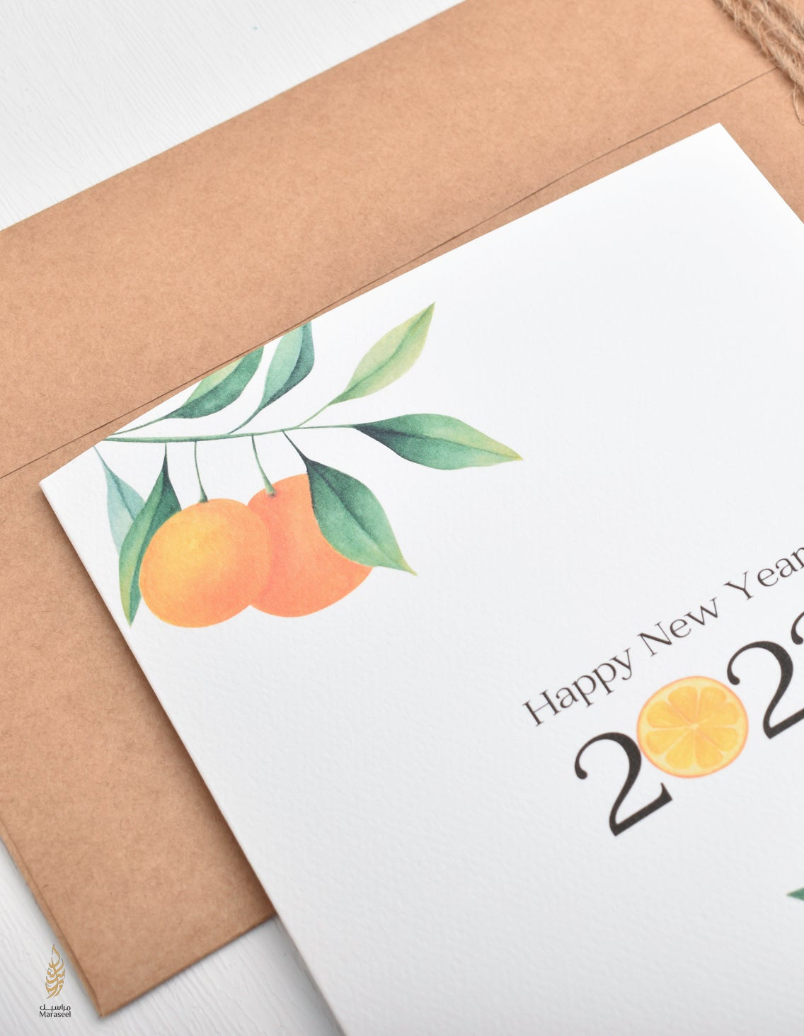 Happy New Year card with illustrated oranges and green leaves on a brown envelope 2026
