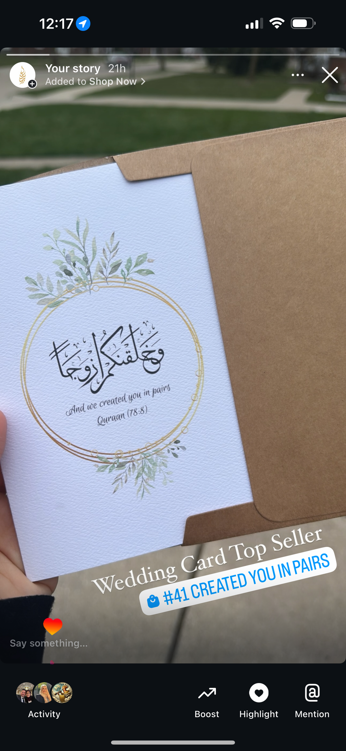 Handheld wedding card with decorative elements on a blurred background