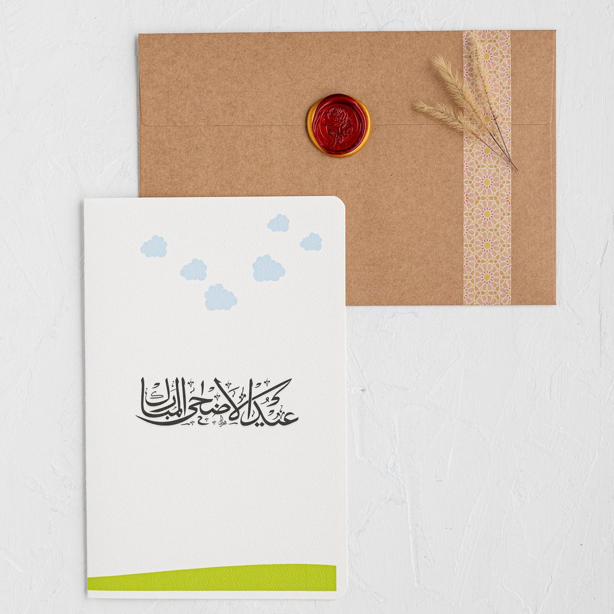 Greeting card with Arabic calligraphy and a brown envelope on a white background