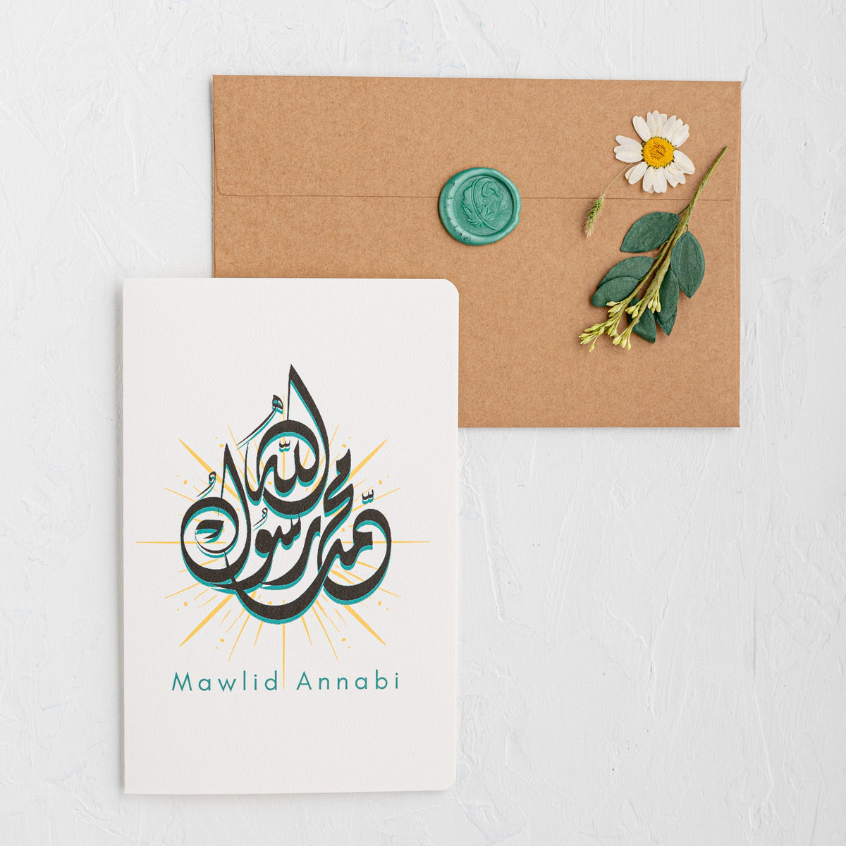 Card with Arabic text 'Mawlid Annabi' featuring a flower and envelope on a white background