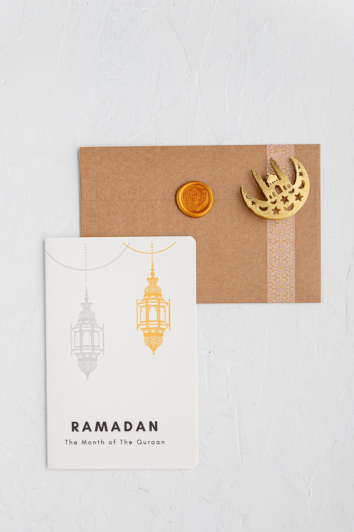 Decorative card with 'Ramadan' text and gold lantern illustrations on a white background.